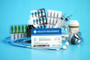 Health insurance card policy with meds and medical equipment on blue background.