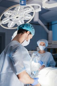 Male and female anesthetists preparing patient before operation in hospital